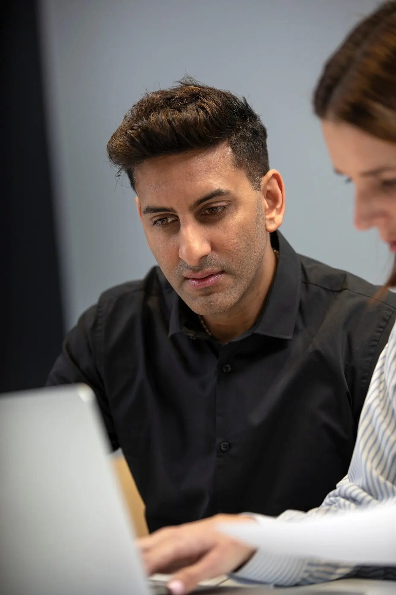 Frau und Mann arbeiten mit einem Laptop.